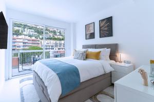 ein Schlafzimmer mit einem großen Bett und einem Balkon in der Unterkunft Luxury Top Floor Sea View Downtown Cap d'Ail in Cap d'Ail