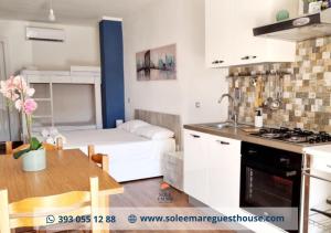 Una cocina y una sala de estar con una mesa y un sofá. en Sole E Mare, en Guardia Piemontese Terme 25 fotos más