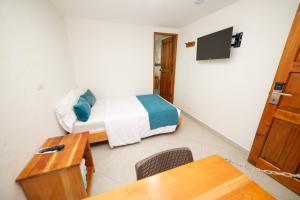 a room with a bed and a table and a desk at Hotel Santa Laura in Jericó
