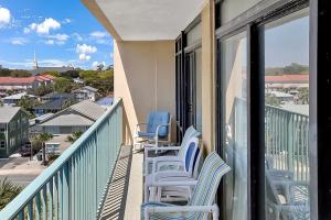 een balkon met blauwe stoelen en uitzicht op een stad bij Verandas 407 in Myrtle Beach