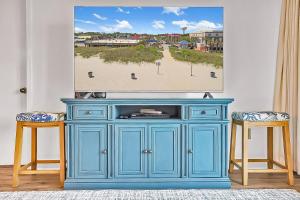 een blauwe kast met twee krukken voor een schilderij bij Verandas 407 in Myrtle Beach