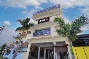 DurgにあるHOTEL O CROWDの前にヤシの木がある建物