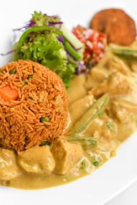 a white plate of food with rice and vegetables at Javelin Palace Hotel in Kampala