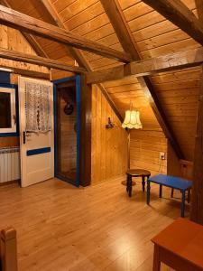 ein Zimmer mit Holzdecke, Tür und Tisch in der Unterkunft Kuća Šarenka in Kupjak