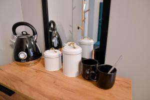 a counter with four coffee cups and a tea kettle at Bolero Apart in Tallinn +20 photos