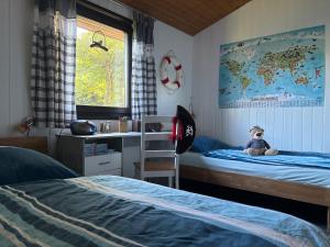 une chambre avec un lit avec un ours en peluche dessus dans l'établissement Urlaub beim Käptn! Freistehendes Premium Nordsee-Ferienhaus mit Fahrrädern, Stellplatz und Garten, 150m zur Nordsee, à Butjadingen