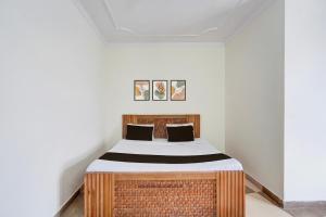 um quarto com uma cama em um quarto branco em Hotel O KK em Haldwani-cum-Kathgodam