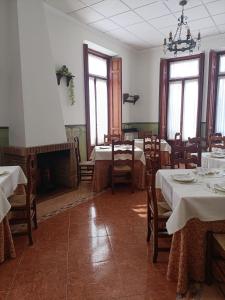 a dining room with tables and chairs and a fireplace at Villa Manolita in Fuensanta