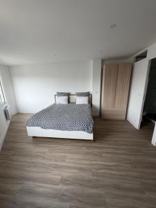 a bedroom with a bed and a wooden floor at Studio neuf à Crosne in Crosne