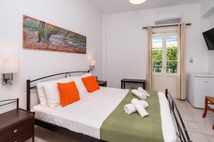 a bedroom with a bed with orange and white pillows at Cyclades Beach in Platis Yialos Sifnos