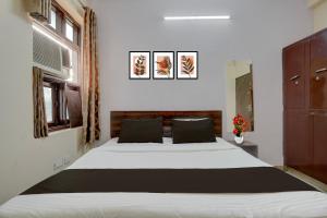 une chambre avec un grand lit dans une pièce dans l'établissement Hotel O Jagatpura Central Railway Station Jaipur, à Jaipur 24 autres photos