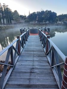 eine Holzbrücke über einen Wasserkörper in der Unterkunft Palast Haus Pousada in Gramado
