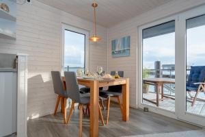 a dining room with a table and chairs with a view at Hausboot Harmonie in Stralsund