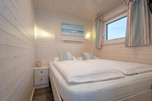 a small bedroom with a bed and a window at Hausboot Harmonie in Stralsund