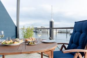 a table with a plate of food on a balcony at Hausboot Harmonie in Stralsund
