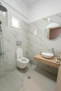 ein Badezimmer mit Toilette, Waschbecken und Spiegel in der Unterkunft Erifili's Apartments in Skala
