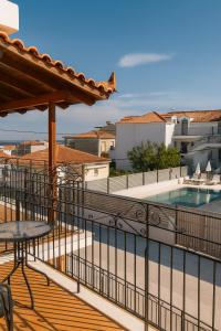 einen Balkon mit einem Tisch und einem Pool in der Unterkunft Erifili's Apartments in Skala
