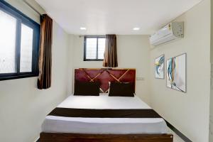 Schlafzimmer mit einem Bett mit weißen Wänden und Fenstern in der Unterkunft Hotel O Jagruti Nagar Ghatkopar Formerly Icy Cool in Mumbai