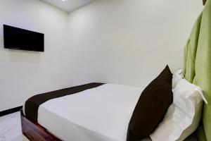 Schlafzimmer mit einem Bett und einem TV an der Wand in der Unterkunft Hotel O Jagruti Nagar Ghatkopar Formerly Icy Cool in Mumbai + 24 Fotos