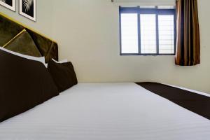 ein Schlafzimmer mit einem großen Bett mit Fenster in der Unterkunft Hotel O Jagruti Nagar Ghatkopar Formerly Icy Cool in Mumbai
