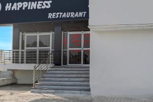 un bâtiment avec des escaliers devant un restaurant dans l'établissement SPOT ON Happyness Restaurant, à Fatwa