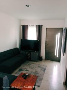 ein Wohnzimmer mit Couch und Flachbildfernseher in der Unterkunft Casa Bellas Artes de 2 pisos en Fracc Privado in Irapuato