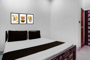 - un lit dans une chambre avec 3 photos sur le mur dans l'établissement SPOT ON Happyness Restaurant, à Fatwa 21 autres photos