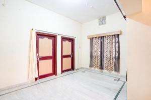 um quarto vazio com portas e janelas vermelhas em SPOT ON Muskan Lodge & Restaurants em Jāmul
