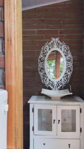 a mirror on top of a white dresser with a mirror at Morada Tito Georgi in Gramado
