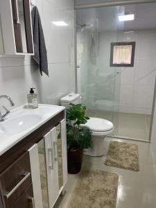 a bathroom with a sink and a toilet and a shower at Morada Tito Georgi in Gramado