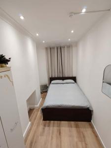 E1 Brick Lane Rooms في لندن: غرفة نوم بها سرير في غرفة بيضاء