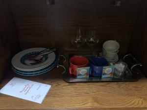 una bandeja con tazas, platos y copas de vino sobre una mesa en Apartment, en Chernivtsi 2 fotos más