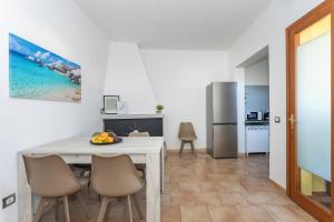 uma cozinha e sala de jantar com mesa e cadeiras em Costa Ovest Apartment 2 em Nurachi