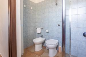 um banheiro com vaso sanitário e chuveiro em Costa Ovest Apartment 2 em Nurachi mais 16 fotografias