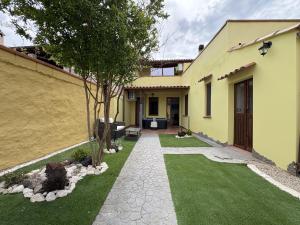 uma casa com um quintal com relva verde em Costa Ovest Apartment 2 em Nurachi