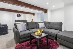 a living room with a gray couch and a table at The Snug- Ideal for Work & Leisure Stays in Bury +11 photos