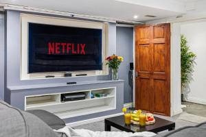 a living room with a television with a netflix at The Snug- Ideal for Work & Leisure Stays in Bury