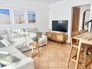 a living room with a couch and a tv and a table at Villa Majanicho Outside con piscina in Majanicho