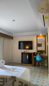 a hotel room with a bed and a flat screen tv at Bursa Hotel Patong in Patong Beach