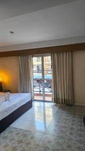 a bedroom with a bed and a large window at Bursa Hotel Patong in Patong Beach