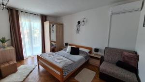 a bedroom with a bed and a couch and a chair at Apartments Solis, 50 m from the sea - Jakišnica in Jakišnica