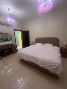 a bedroom with a large bed with pink lights at Lulu Luxury Apartment 1 one Bedroom in Al Khobar
