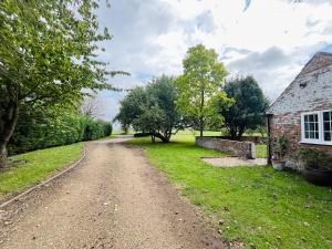 un camino de tierra junto a una casa de ladrillo en The Annexe at Entry House, A Tranquil Rural Escape, en Spalding 6 fotos más
