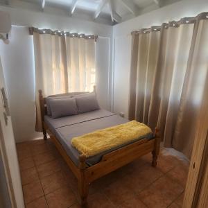 a small bed in a room with curtains at Kingdom Rentals - AirBnCar in Roseau +35 photos