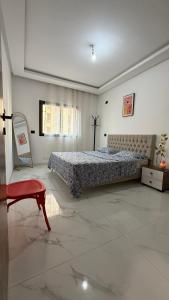 a large bedroom with a bed and a red chair at Premium Suite - Ain zaghouen - proche aeroport - linge hotel in El Aouina Station