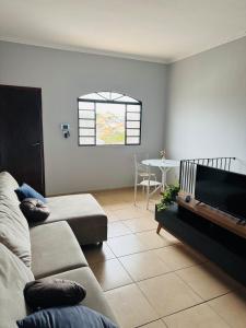 un salon avec un canapé et une télévision à écran plat dans l'établissement Casa próxima ao centro a 3 min de carro, à São Lourenço