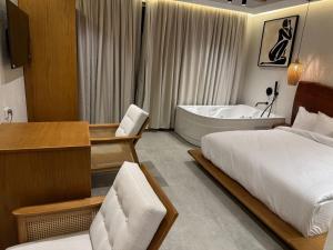 a bedroom with a bed and a bathtub and a bed and a desk at ONE GATE Pyramids View INN in Cairo