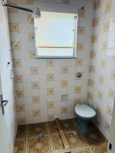 une petite salle de bain avec toilettes et fenêtre dans l'établissement Casa próxima ao centro a 3 min de carro, à São Lourenço 15 autres photos