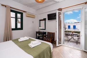 a bedroom with a bed and a balcony at Cyclades Beach Apartments in Platis Gialos