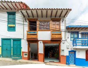 a building with blue doors and wooden balconies at Hotel Santa Laura in Jericó +163 photos